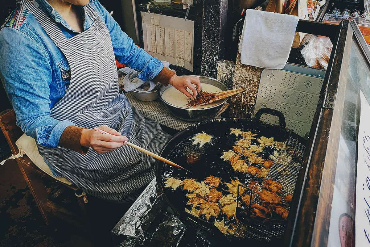 Lady making maple leaf tempura in Minoo