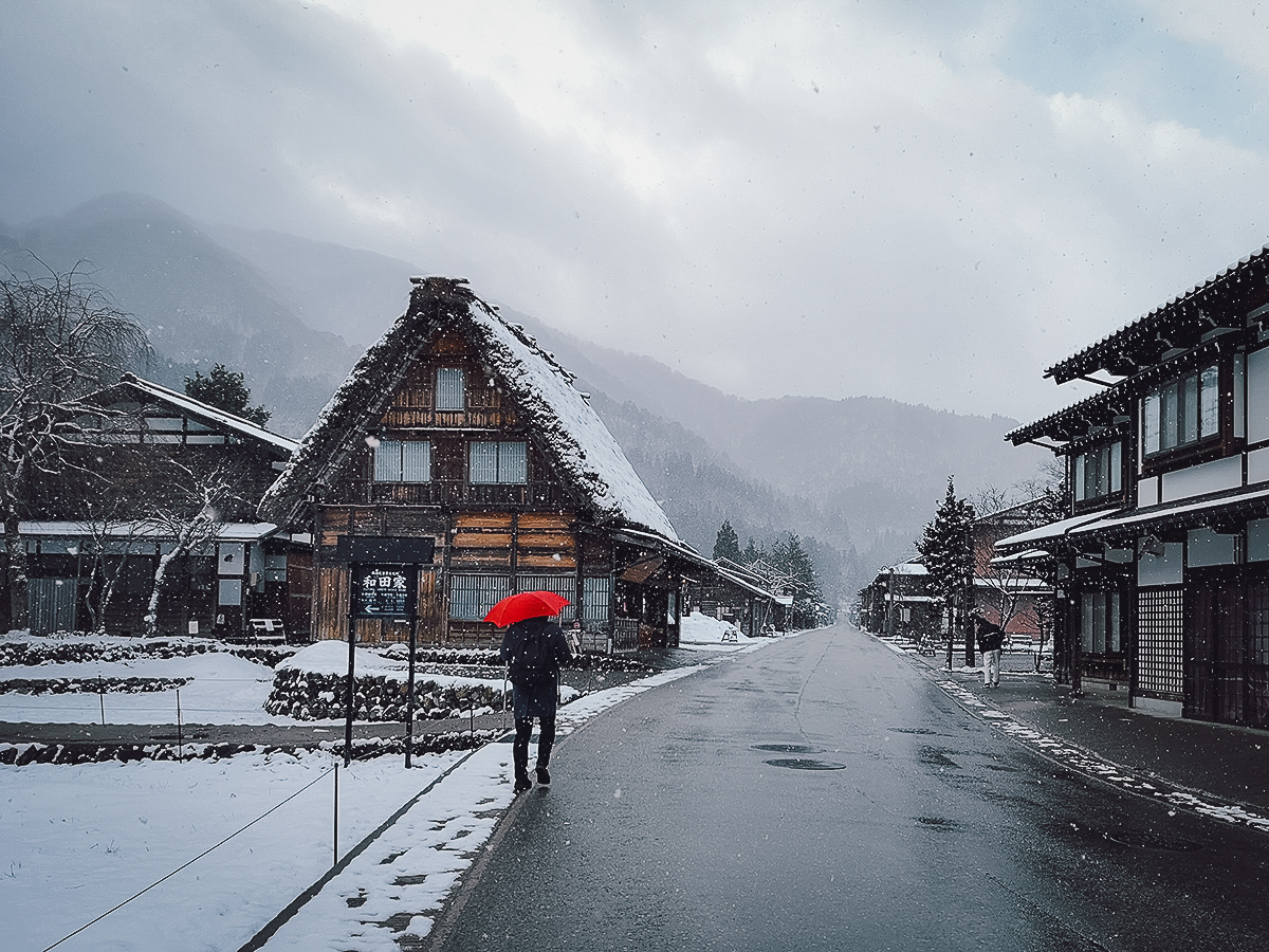 Tourist with red umbrells exploring Ogimachi Village