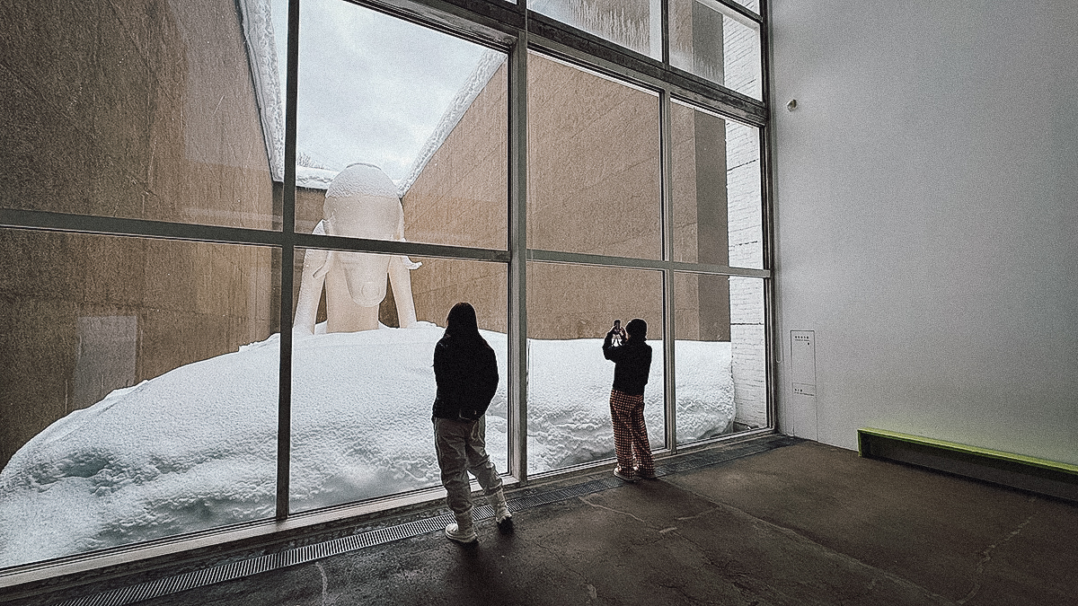 Visitors taking pictures of the dog sculpture at Aomori Museum of Art
